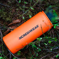 Orange pouch with 'INCREDIWEAR' branding on a forest floor
