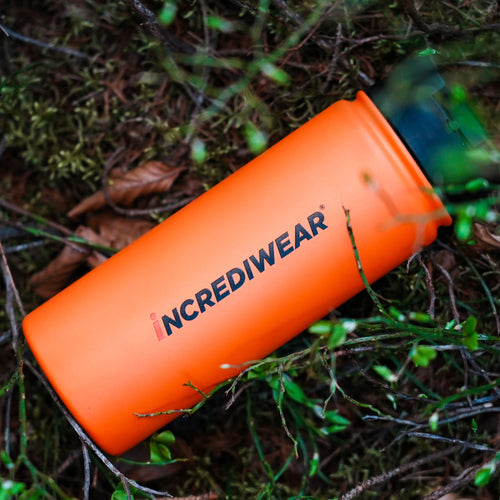 Orange pouch with 'INCREDIWEAR' branding on a forest floor