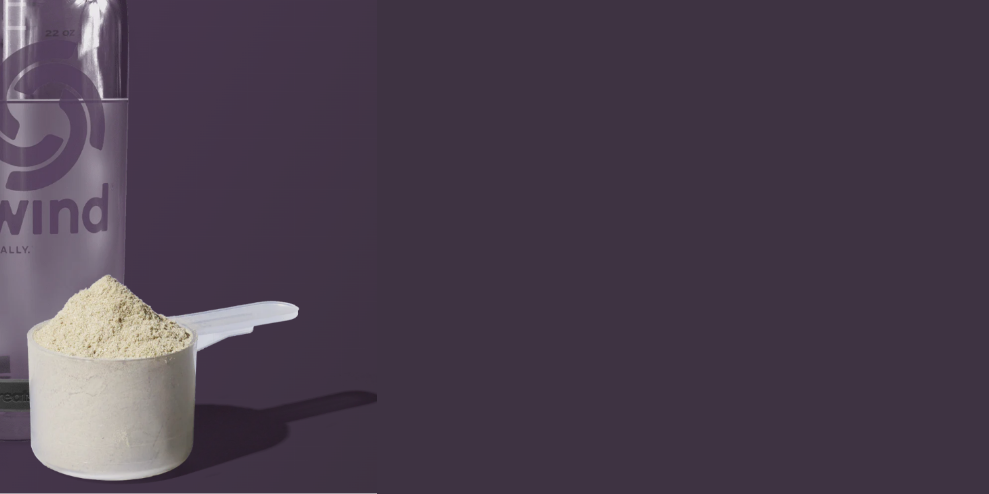White scoop with protein powder and a purple 'Tailwind' container on a dark background