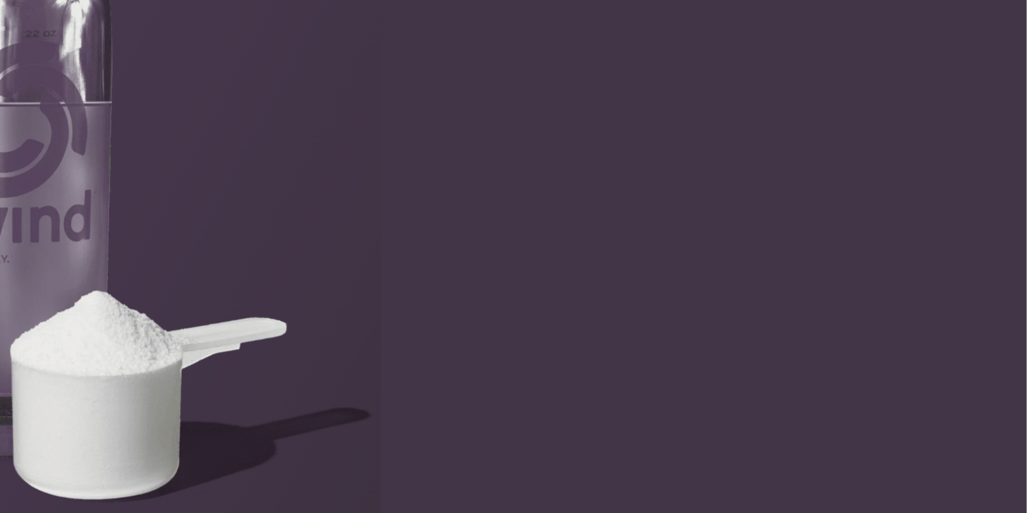 White scoop with protein powder next to a purple container on a dark background