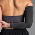 Person wearing a dark gray arm sleeve against a neutral background