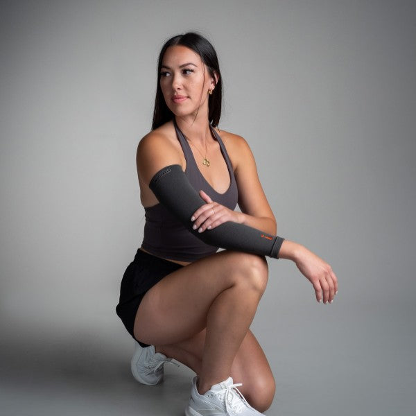 Woman wearing a black arm brace on a gray background
