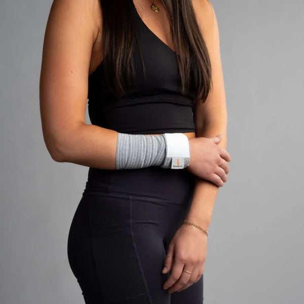 Person wearing a black sleeveless top and leggings with a gray bandage wrap band on a gray background