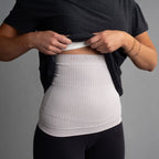 Person wearing a white compression garment with 'Incredibly' branding on a gray background