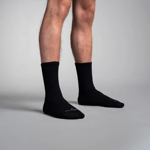 Black circulation crew socks worn by a person on a gray background