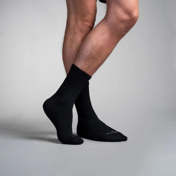 Black circulation CREW socks worn by a person on a gray background