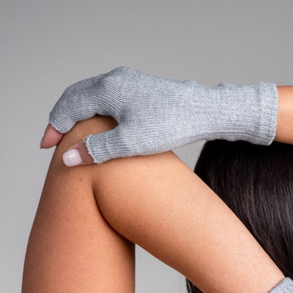 Person wearing a gray fingerless glove on one hand against a neutral background