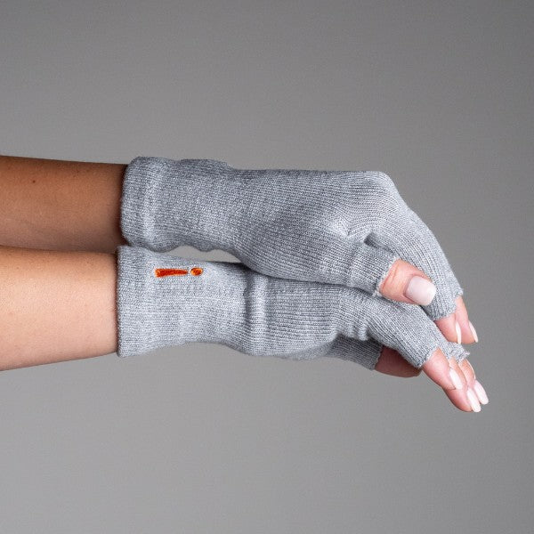 Gray fingerless gloves worn on a neutral background