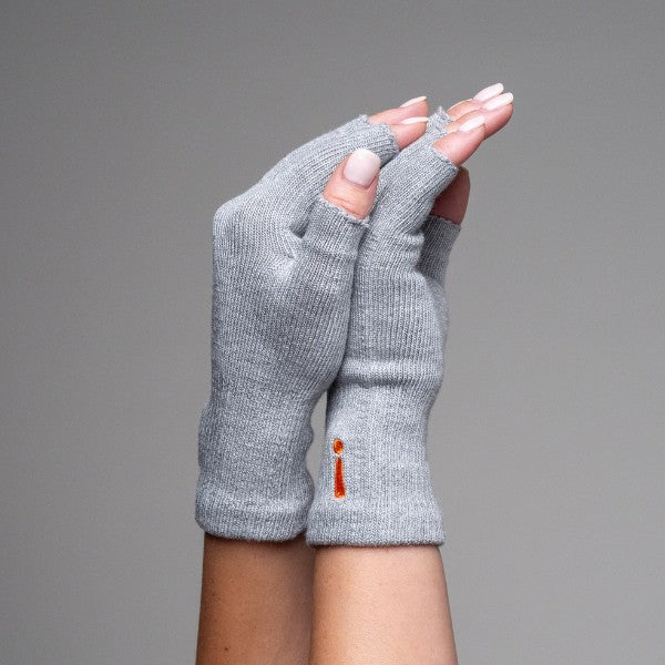 Gray fingerless gloves held by a hand against a gray background