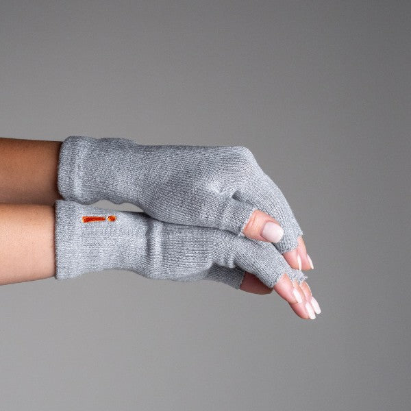 Gray fingerless gloves worn on a neutral background