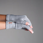 Gray fingerless gloves worn on a neutral background