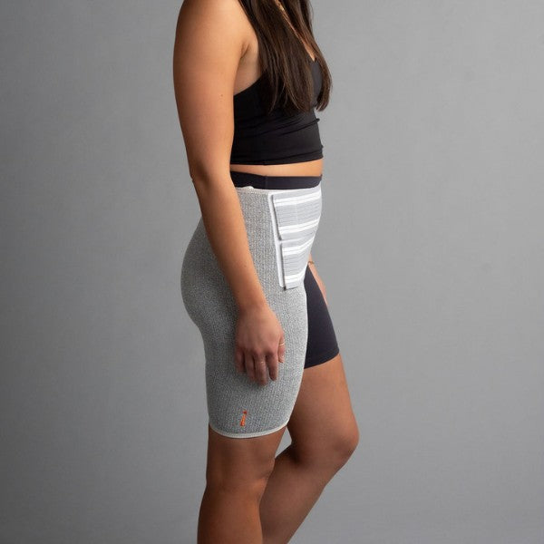 Person wearing a gray hip brace with a gray background