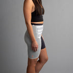 Person wearing a gray hip brace with a gray background