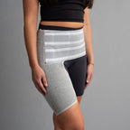 Person wearing a gray compression garment on their leg against a gray background