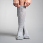 Gray knee-high socks with an orange logo on a gray background