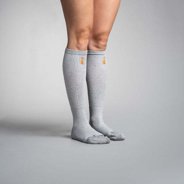 Gray knee-high socks with a brand logo on a gray background