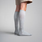 Gray knee-high socks worn by a person on a plain background