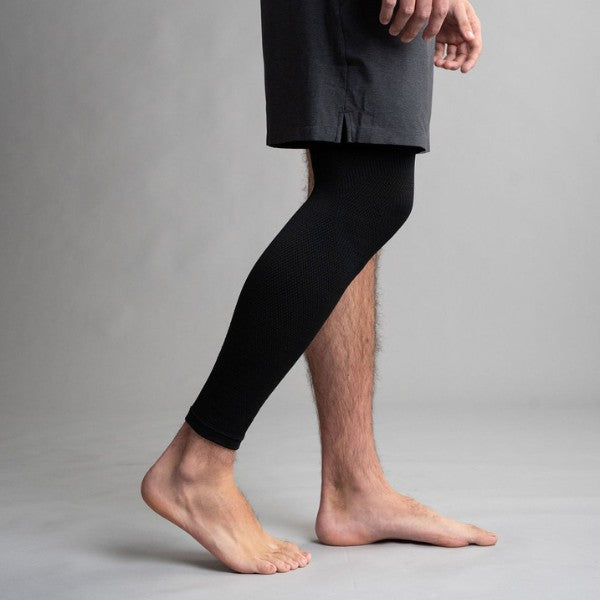 Person wearing black compression sleeve on a gray background