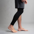 Person wearing black compression sleeve on a gray background