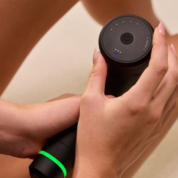Person holding a black electronic device with a green accent