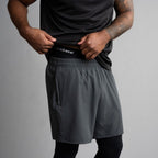 Person wearing black athletic shirt and black long pants with 'incrediwear' branding on a gray background