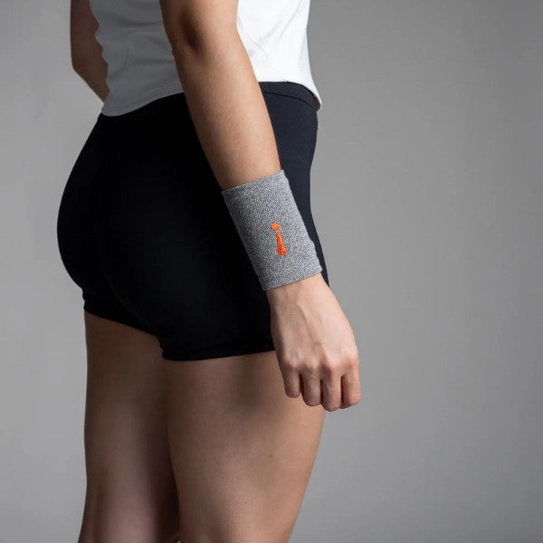 Person wearing a gray wristband with an orange logo on a plain background